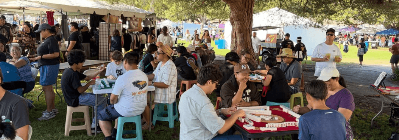 Filipino Mahjong social event in action with multiple tables of community members playing outdoors